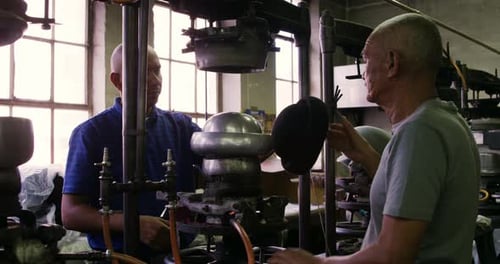 Mixed race men working at a hat factory