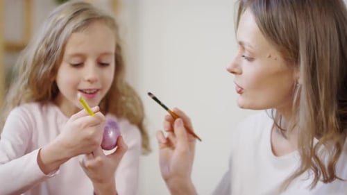 Happy Mother and Daughter Decorating Easter Eggs
