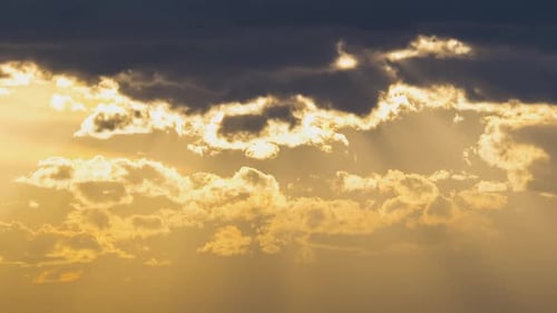 Golden Sunlight Piercing Through Cloudy Sunset Sky