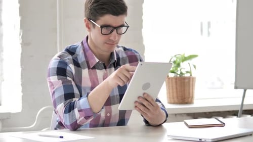 Young Adult Working on Tablet in Bright Office