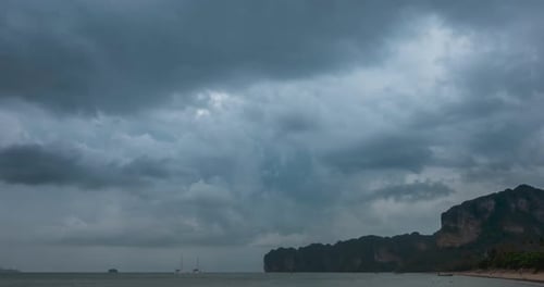 Zeitraffer von Regenwolken über Strand und Meereslandschaft mit Booten. Tropischer Sturm im Meer
