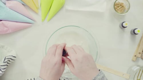 Time lapse. Step by step. Flat lay. Mixing royal icing to decorate Easter sugar cookies.