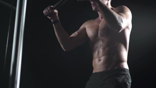 Athletic Man in the Gym Lifting Blocks on Rowing Machine Training on Block Device and Gym Equipment