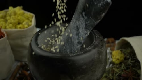 Grains Falling into Mortar with Herbs and Spices