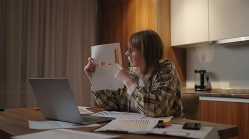 Woman Presents Charts During a Virtual Home Meeting