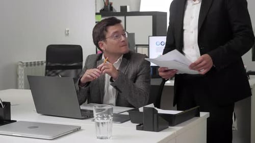 Two Man at the Office Discuss Documents