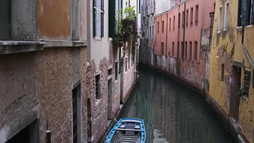 Narrow Canals of Venice with Gondolas Parked on Water Between Colorful Houses