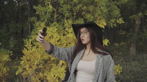Stylish Woman Taking Selfie in Autumn Park