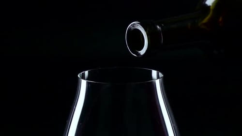 Pouring Red Wine into Glass in Dark Setting
