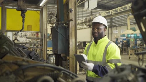 Black African American man, an engineer or worker use tablet device to control smart robot