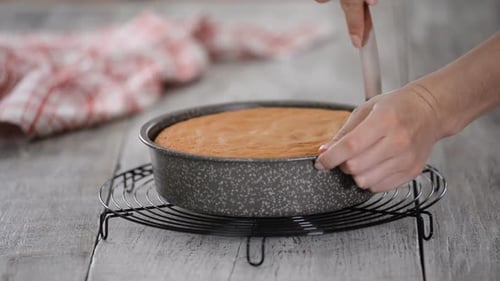 Konditorei nimmt den Kuchen aus der Kuchenform.