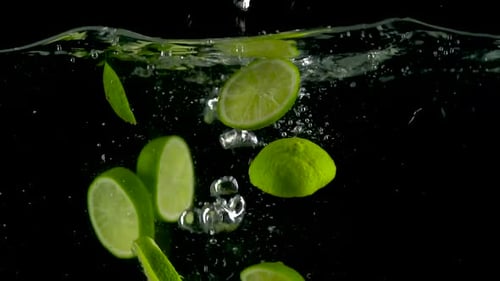 Lime Slices Splashing into Water