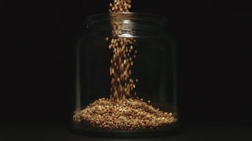 Buckwheat Grains Filling Up a Glass Jar
