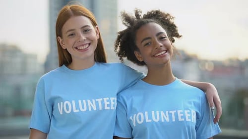 Two Female Volunteers Smiling on Camera, High School Charity Program, Altruism