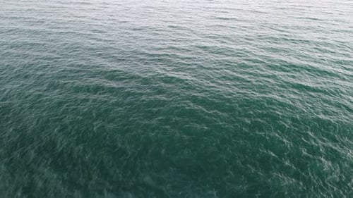 Luftbild von oben auf ruhiges azurblaues Meer und vulkanische Felsküsten