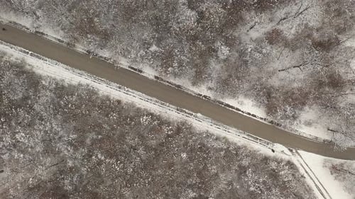 Pedestrian walks on snowed forest road 4K aerial footage