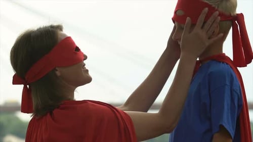 Woman and Child in Superhero Costumes Bonding