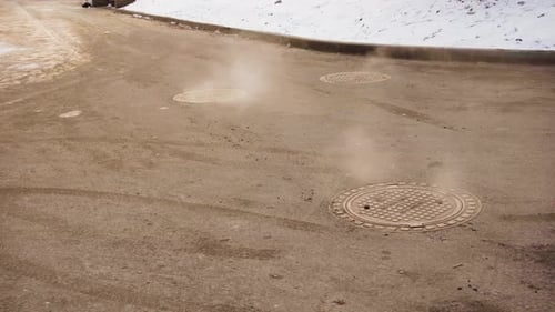 Vapor Rising from Manhole Covers in Winter
