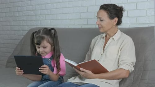 Woman and Child Reading and Using Tablet