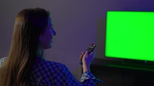 Woman Uses Remote Control in Dark Room