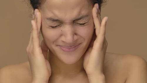 Woman Massages Temples to Relieve Headache Discomfort