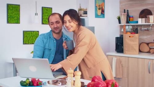 Couple Using Laptop in Bright Kitchen Together
