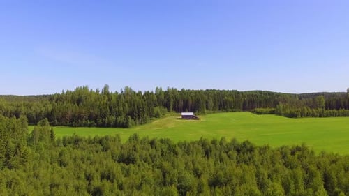 Langsam von links nach rechts schwenkendes Video einer einsamen Scheune in der finnischen Landschaft mitten im Fo