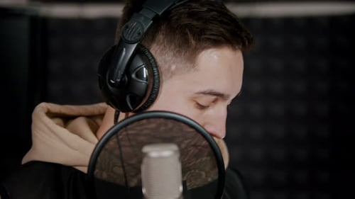 A Young Man Rapper Recording His Track in the Sound Recording Studio