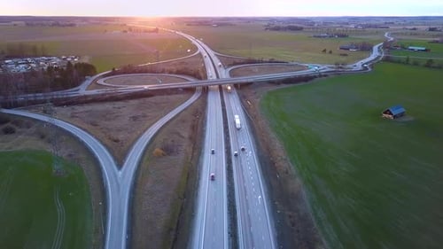 Aerial view of freeway intersection with moving traffic cars.
