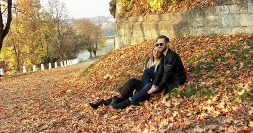 Beautiful Autumn View with Couple in Love Relaxes Caresses Each Other on Lawn