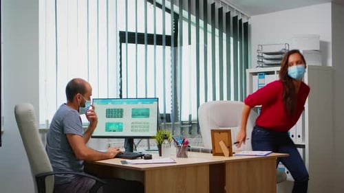 Coworkers Reviewing Data Charts in a Modern Office