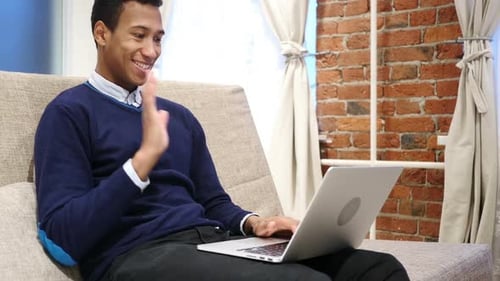 Young Man Using Laptop on Sofa