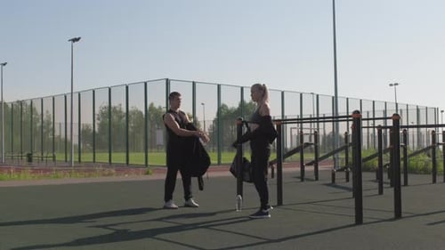 Adults Warming Up on Outdoor Workout Lot