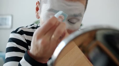 Young Adult Applies White Makeup To Face