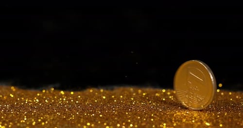 Münze von 1 Euro auf Goldpulver vor schwarzem Hintergrund, Zeitlupe 4K