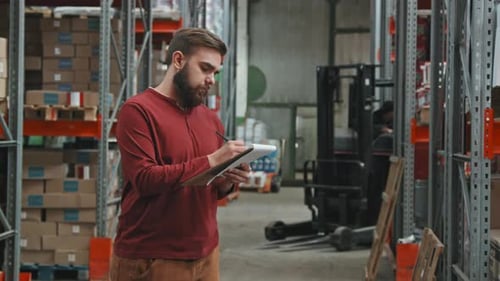 Man Checking Inventory in Warehouse and Posing