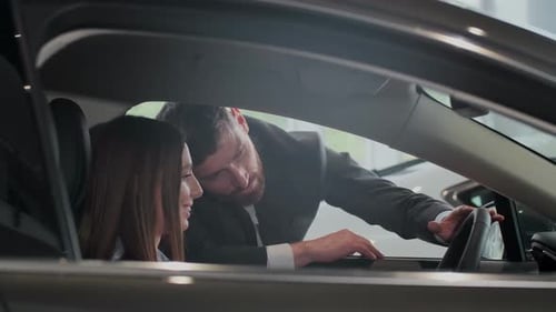 Car Salesman Demonstrating Features to Potential Customer