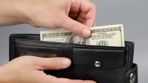 Hand Inserts Hundred Dollar Bill Into Wallet