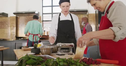 People Cooking Pasta Together in Bright Kitchen