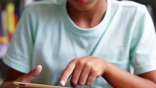 Schoolboy using digital tablet in classroom at school
