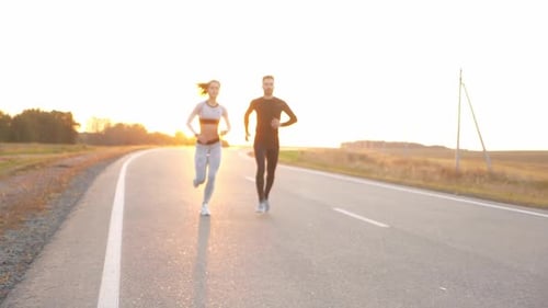 Couple Running on Rural Road at Sunset