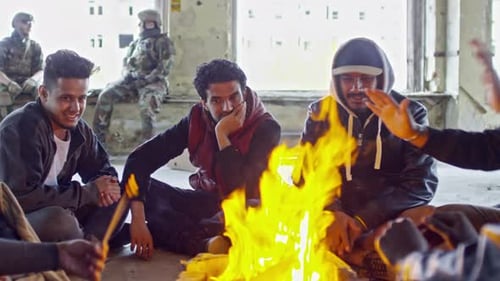 Refugiados árabes se calientan por el incendio en edificio destruido