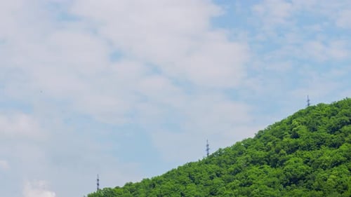 Sky Cloud Timelapse in Background of High Voltage Tower on Green Mountain