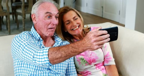 Smiling Couple Takes Selfie on the Couch
