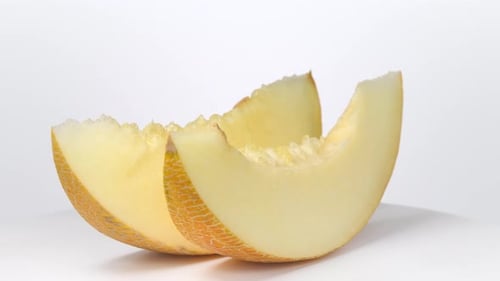 Melonenscheiben rotieren auf weißem Hintergrund