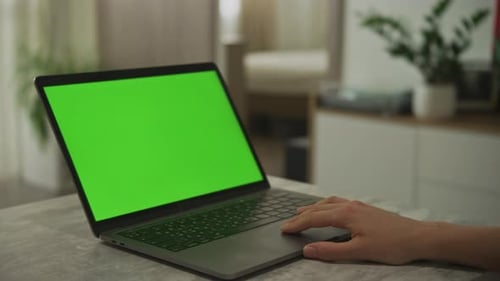 Caucasian Woman's Hand Swiping on a Laptop Touchpad with a Chroma Key Green Screen on It