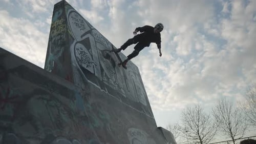 Skateboarder Does Trick on Graffiti Ramp