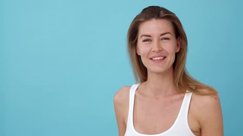 Smiling Woman with Blonde Hair in Front of Blue