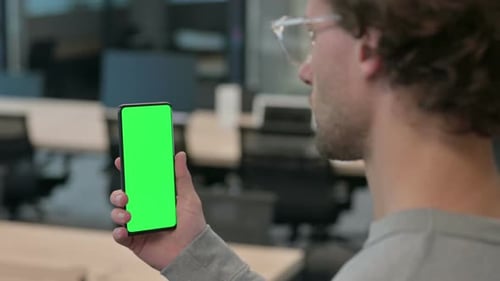 Rear View of Young Businessman Using Smartphone with Chroma Screen