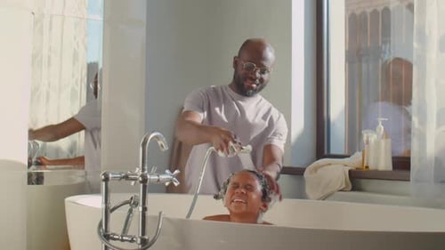 Loving Father Washes Daughter's Hair in Bath
